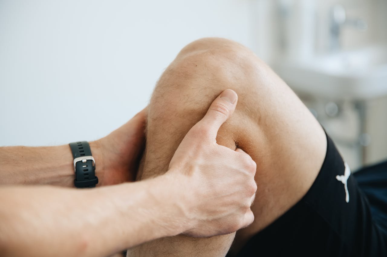 Close-up of a physiotherapist massaging a patients knee during therapy.